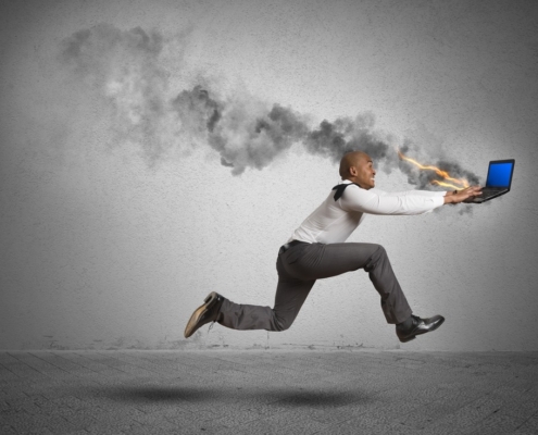 man running behind burning computer