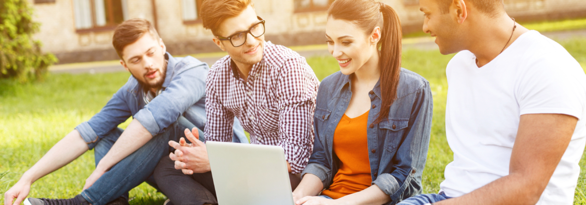 A diverse group of students demonstrating the results of simplifying SaaS adoption, gather outside a university building, looking at a laptop and each other