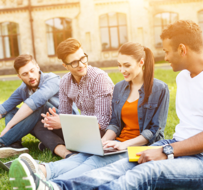 A diverse group of students demonstrating the results of simplifying SaaS adoption, gather outside a university building, looking at a laptop and each other